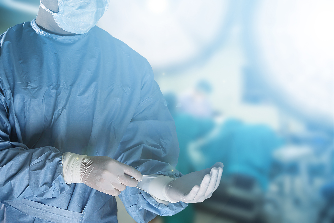 Médico colocando luva no centro cirúrgico